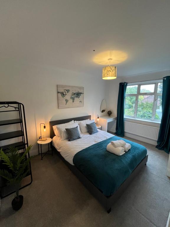 a bedroom with a large bed and a window at Cosy 2 Bed Maisonette near Heathrow & Windsor in Staines