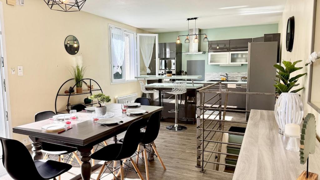 une cuisine et un salon avec une table et des chaises dans l'établissement Le refuge, Wifi, Parking privé, Proche Limoges, terrasse, jardin, à Le Palais-sur-Vienne