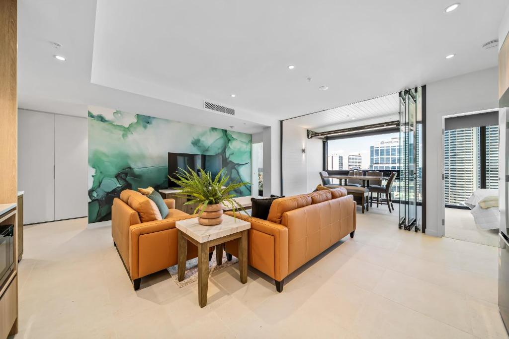 a living room with two couches and a tv at Luxury Perth CBD Apartment with Pool & Gym in Perth