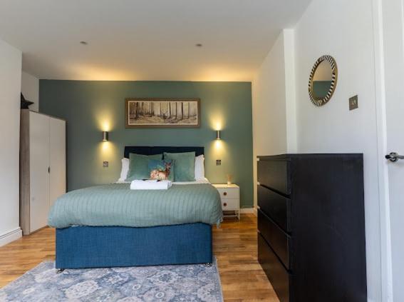 a bedroom with a bed with a dog sitting on it at Little Gem in the Forest of Dean! Hot tub, Private garden, Dog Friendly, Smart TVs and Beautiful Historic Village Location! in Saint Briavels