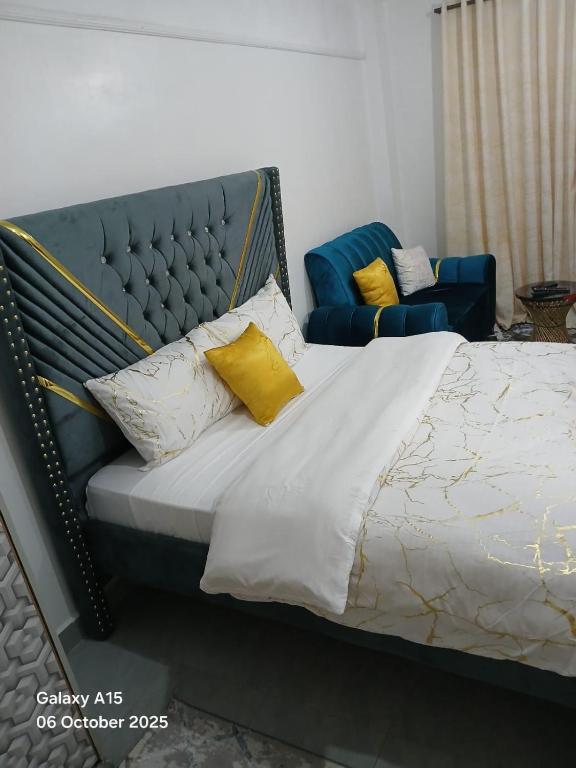 a bedroom with a large bed with yellow pillows at Crystal Zuri Homes, Kasarani in Nairobi