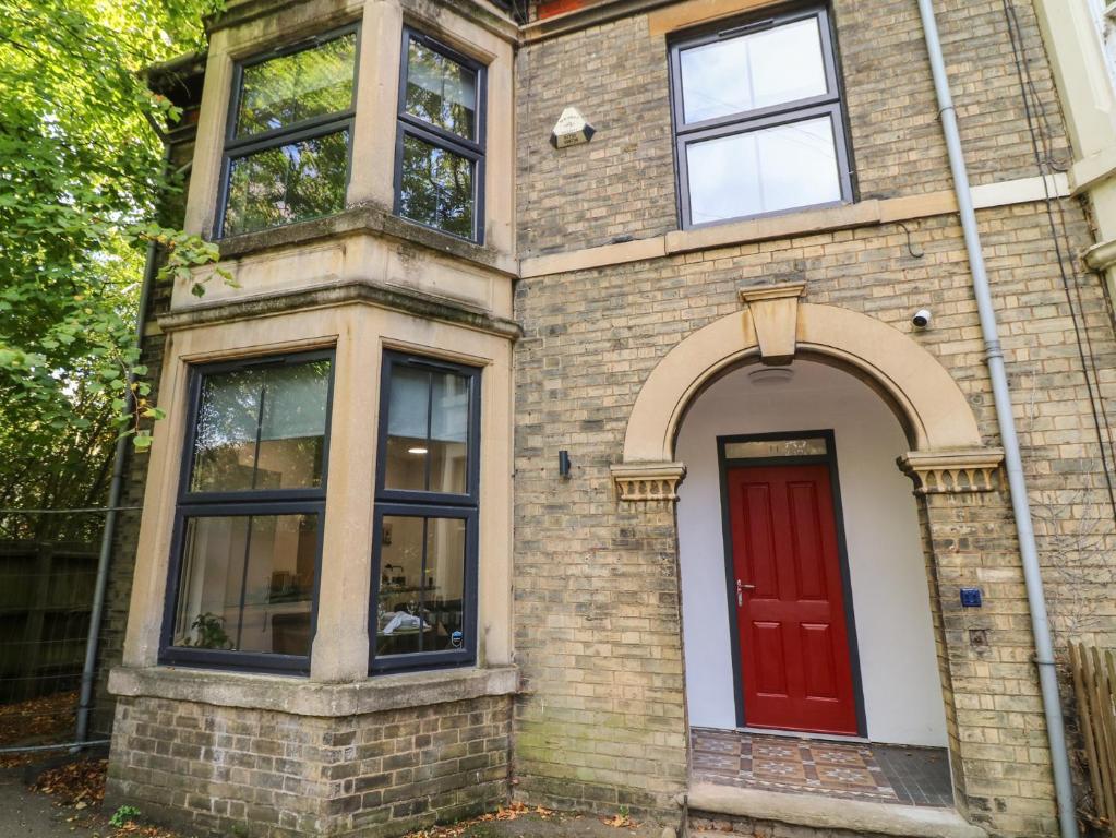 a brick house with a red door and windows at Two in Peterborough