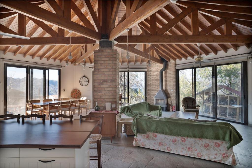 a living room with wooden ceilings and a dining room at Orama Mountain Villa Farmakas in Nicosia