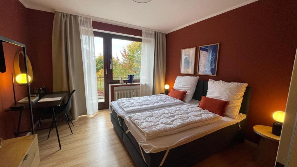 Un dormitorio con una cama y un escritorio y una ventana. en Bahnhof Suites I 3 Zimmer I Komfort mit Aussicht und 3 Balkonen, en Bad Bevensen