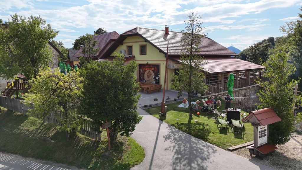 a house with a group of people sitting in the yard at Farm Stay Šolinc in Laško
