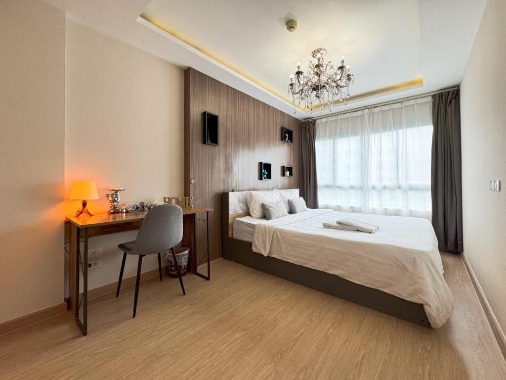 Un dormitorio con una cama, un escritorio y una silla. en Pool View Cozy 1BR Great Value Stay near BTS, en Amphoe Phra Khanong