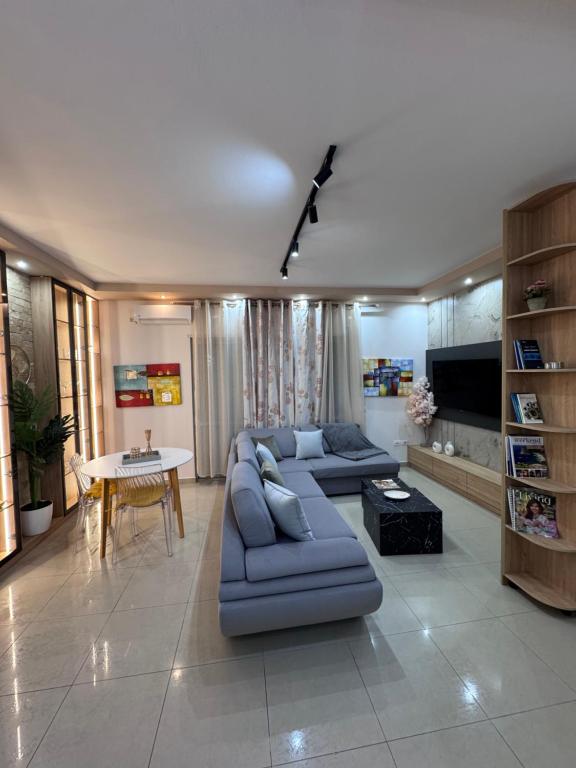 a living room with a blue couch and a table at Star Vollga Luxe Apartment in Durrës