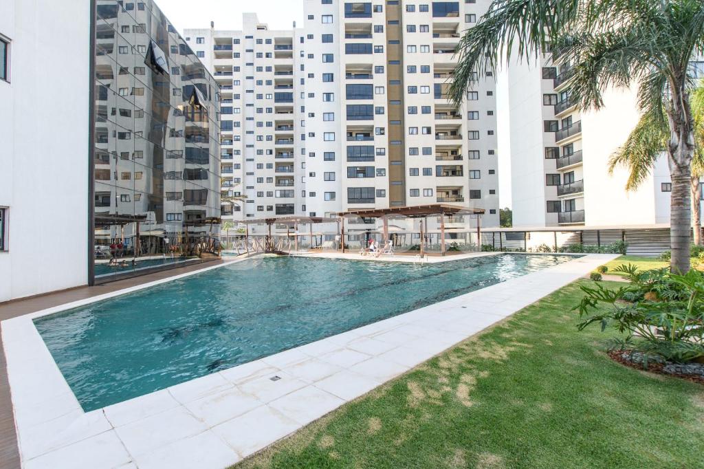 a swimming pool in a building with tall buildings at Cozy 2 Br In Ciudad Del Este in Puerto Presidente Franco