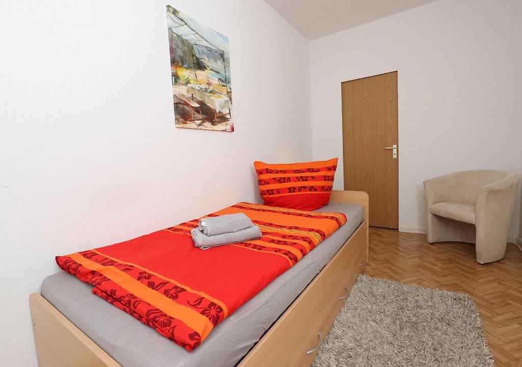 a bed in a room with a red blanket on it at Ferienwohnung Inselzoo der WAG in Altenburg