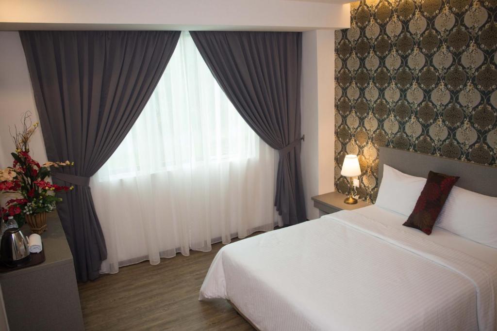 Postel nebo postele na pokoji v ubytování Qlassic Hotel