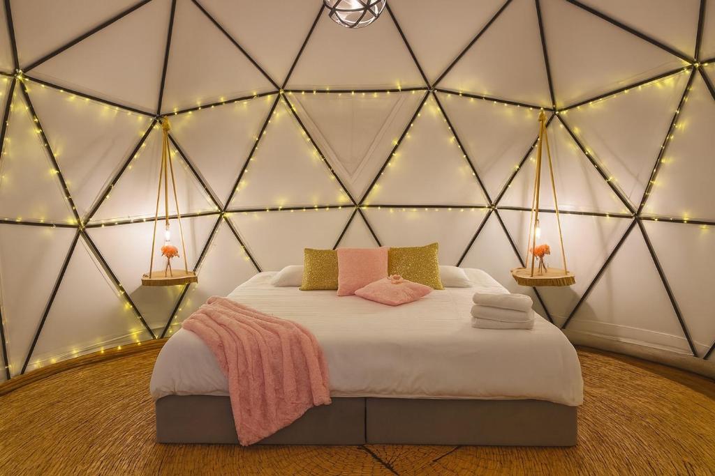 a room with a bed in a triangular room with lights at Glamping exclusivo de lujo en la montaña in Suesca