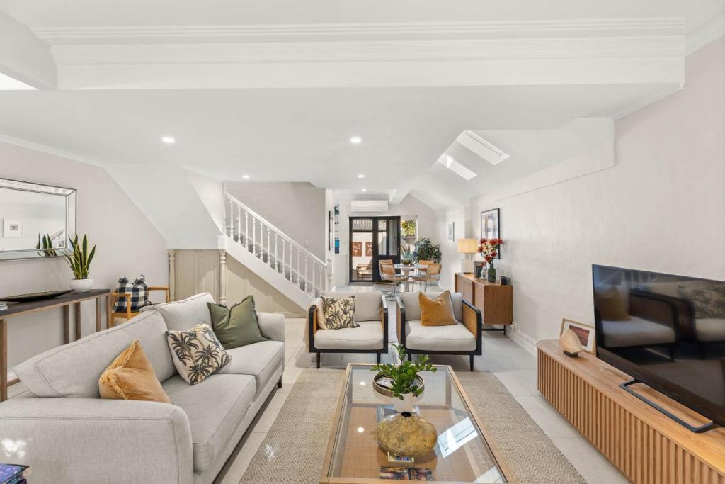 a living room with a couch and a tv at Beautiful Terrace Home with Courtyard in Newcastle
