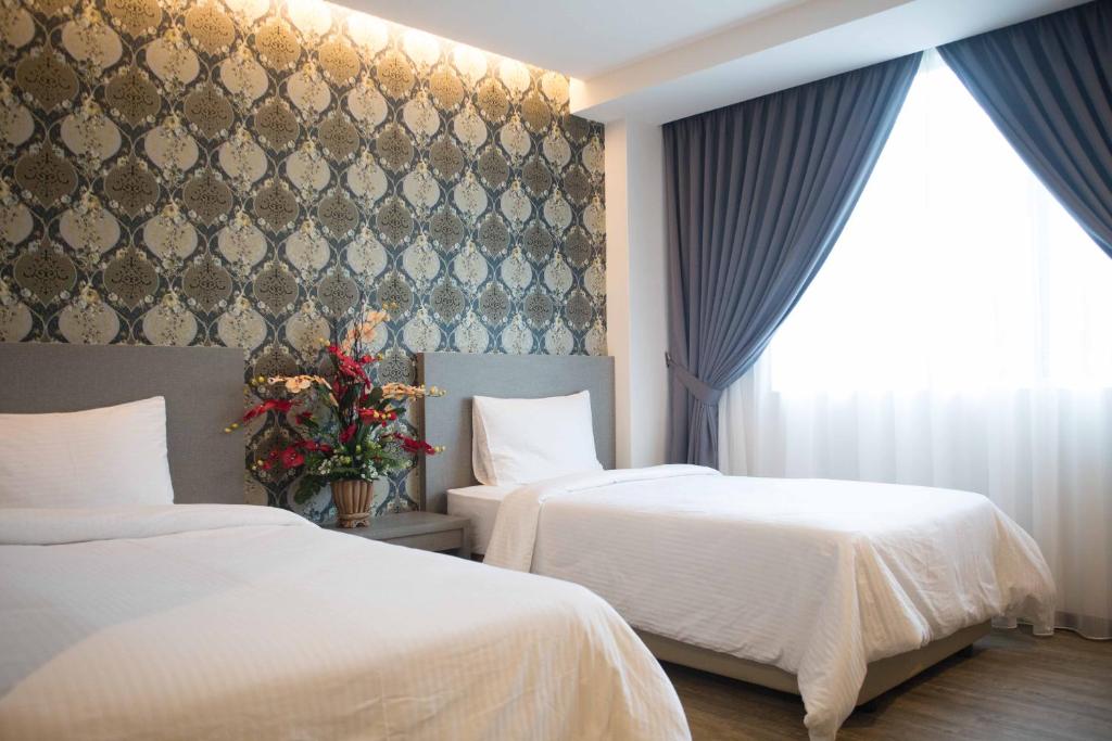 Postel nebo postele na pokoji v ubytování Qlassic Hotel