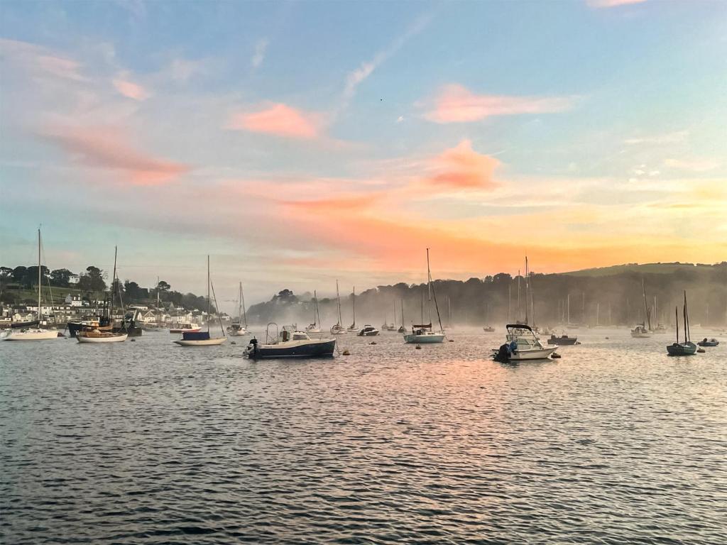 a group of boats in the water at sunset at The Lookout in Polruan