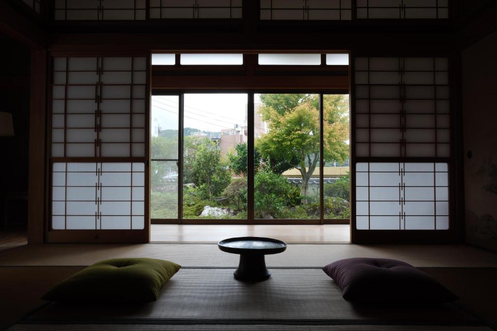 a room with a window and a table and pillows at Shimanto Suite By Hideaway in Shimanto