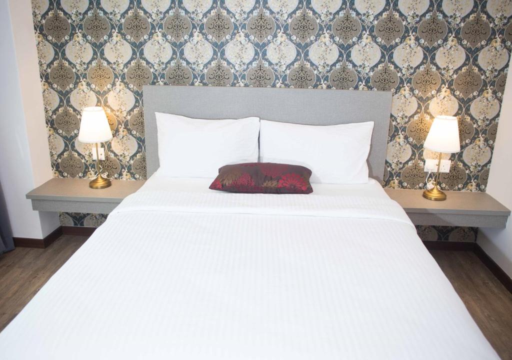 Postel nebo postele na pokoji v ubytování Qlassic Hotel