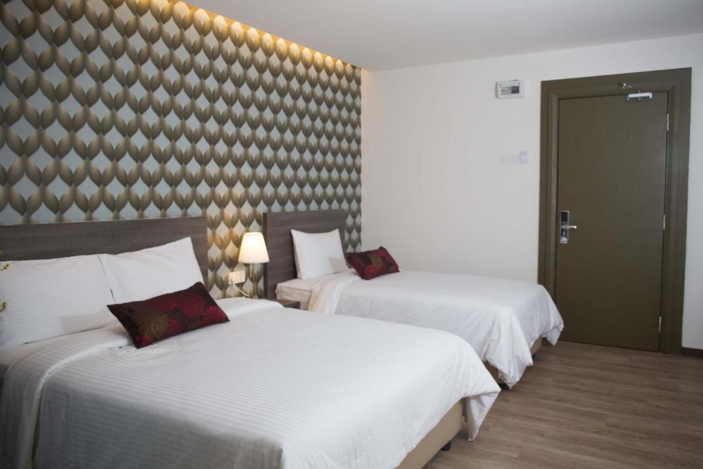 Postel nebo postele na pokoji v ubytování Qlassic Hotel