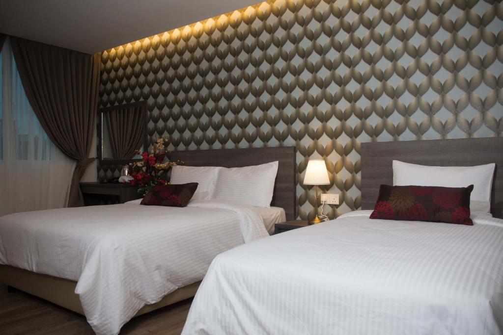 Postel nebo postele na pokoji v ubytování Qlassic Hotel