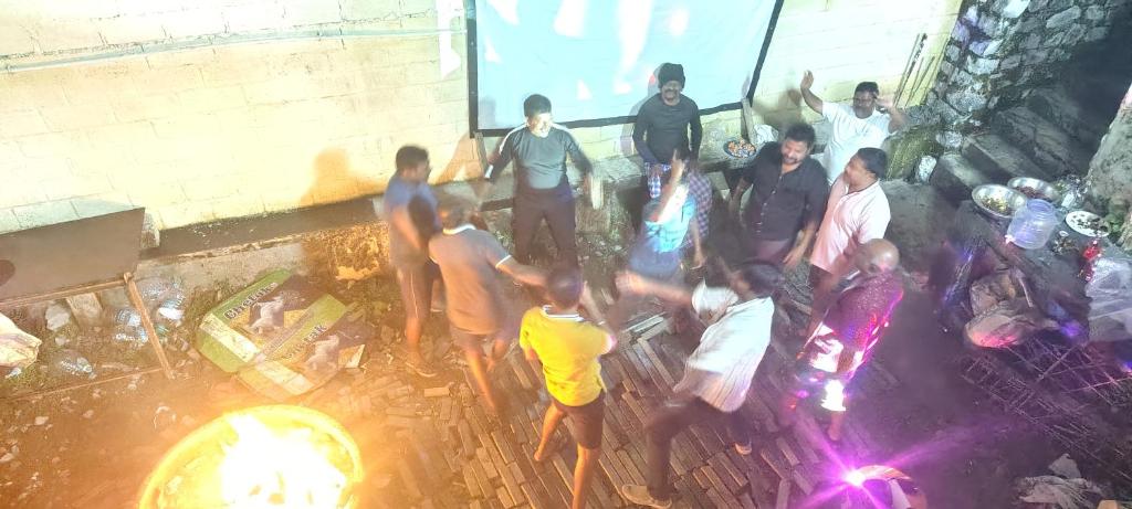a group of people standing in front of a fire at HILL BIRD HOME STAY Ooty in Ooty