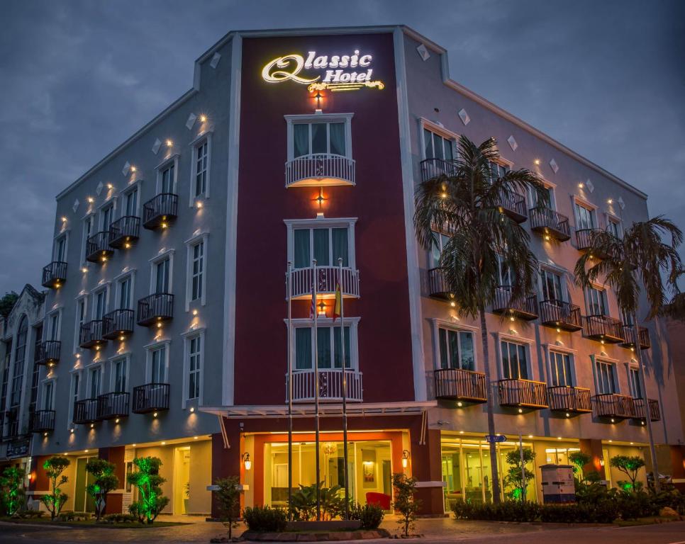 um hotel com um sinal ao lado em Qlassic Hotel em Sepang