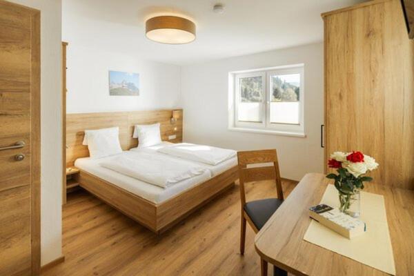a bedroom with a bed and a desk and a table at Landhaus im Feld in Sankt Michael im Lungau