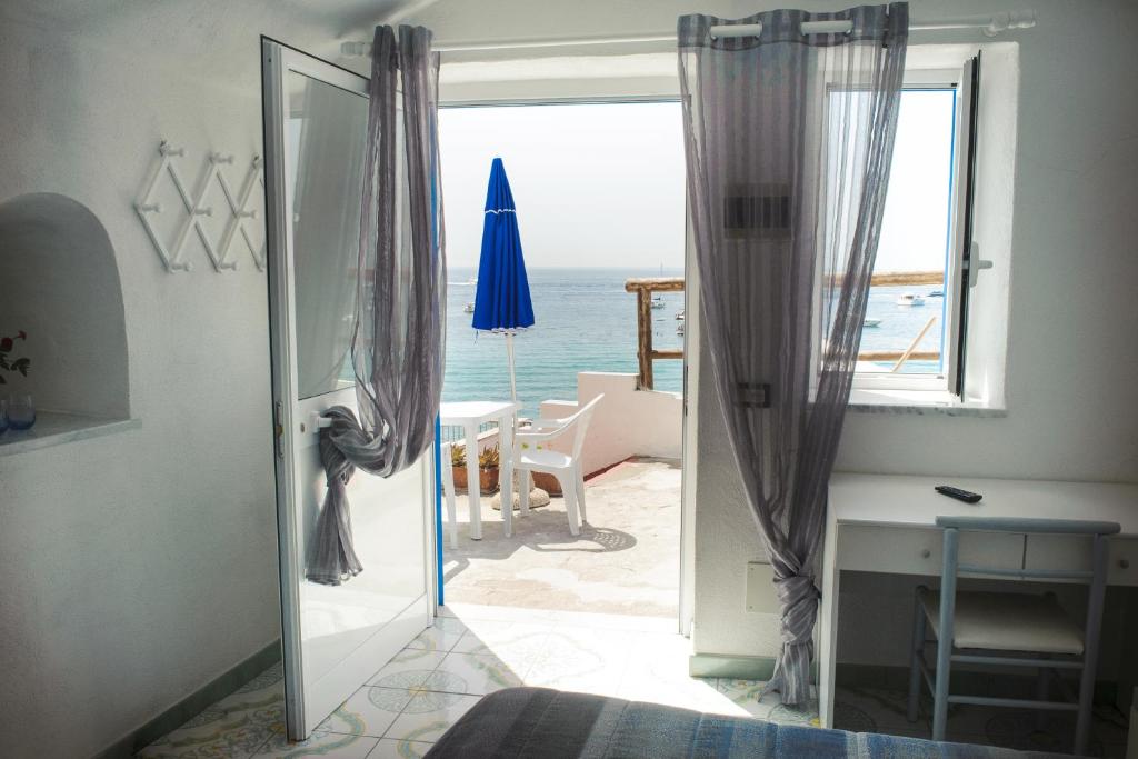 a door to a room with a view of the ocean at Hotel Regina del Mare in Ischia