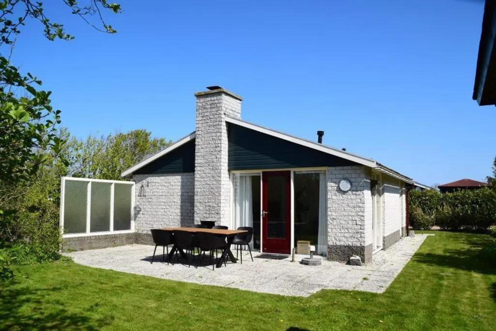 a white brick house with a table in the yard at Bungalow 049 in Petten