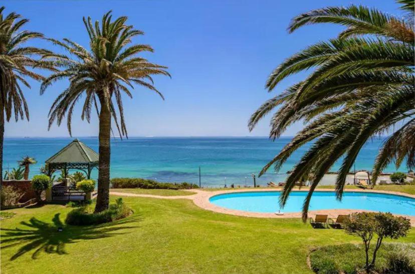 a resort with a swimming pool and the ocean at Modern Apartment - Home away from home in Summerstrand