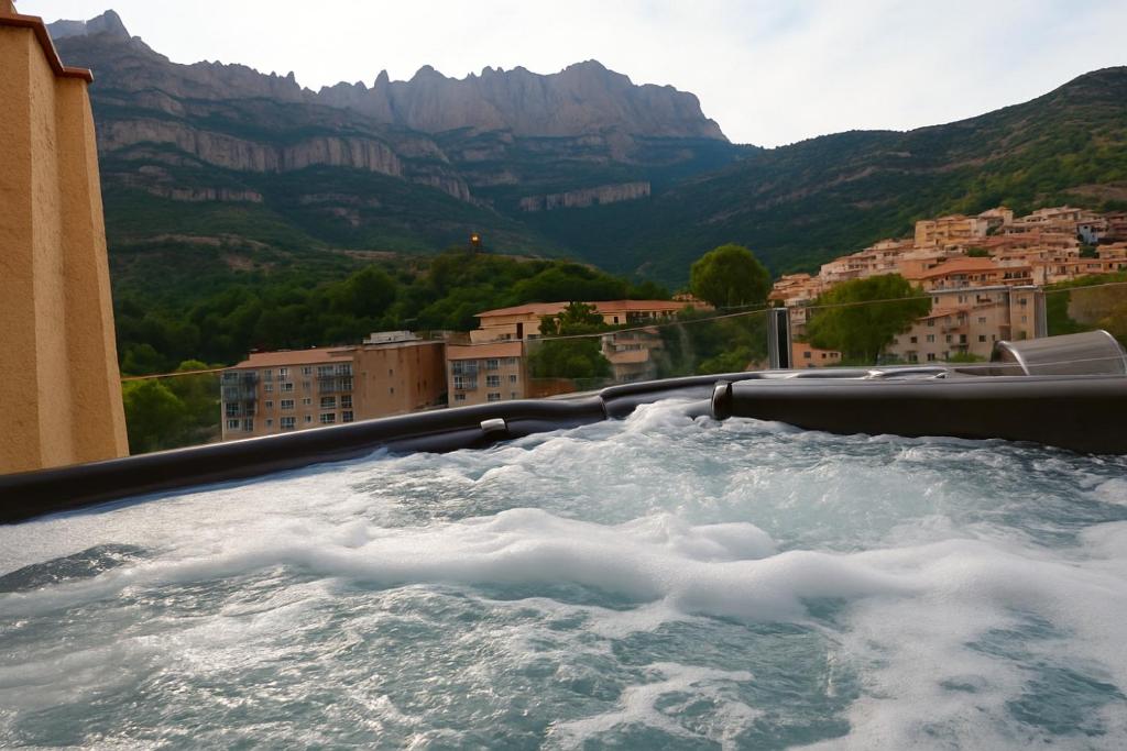 Una bañera de hidromasaje con agua, edificios y montañas. en Apartamento en Montserrat- Montserrat Paradise Apartament, en Monistrol