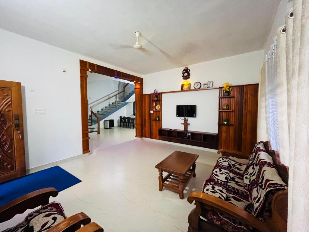 ein Wohnzimmer mit Sofa und Fernseher in der Unterkunft Sharada Nest in Sringeri