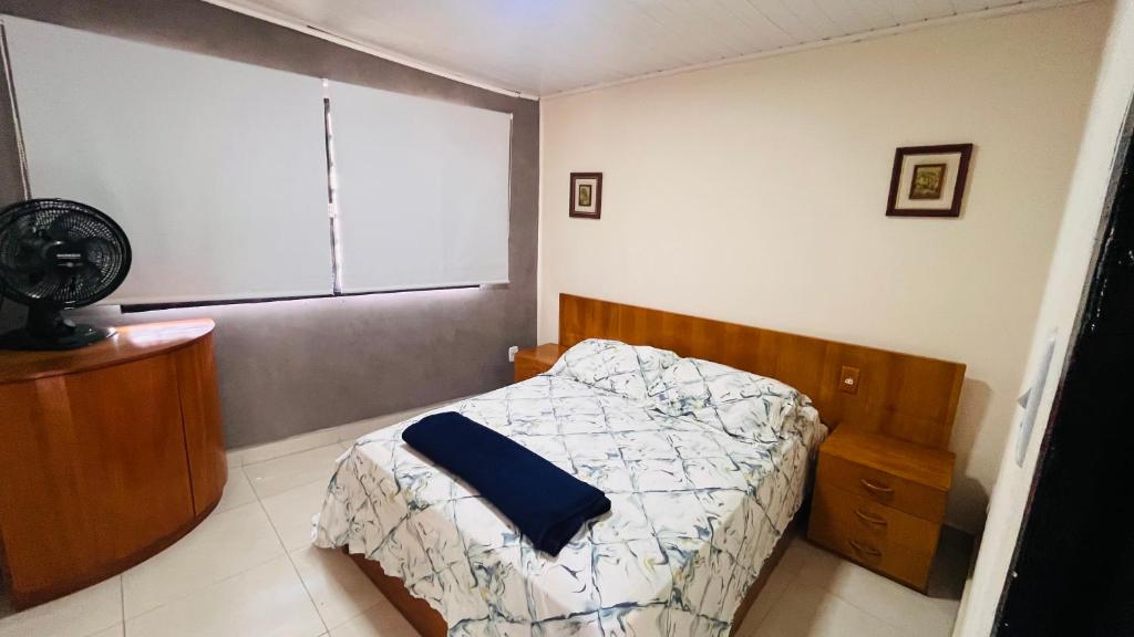 a small bedroom with a bed and a window at Apartamento Aconchegante Perto da Dutra in Taubaté