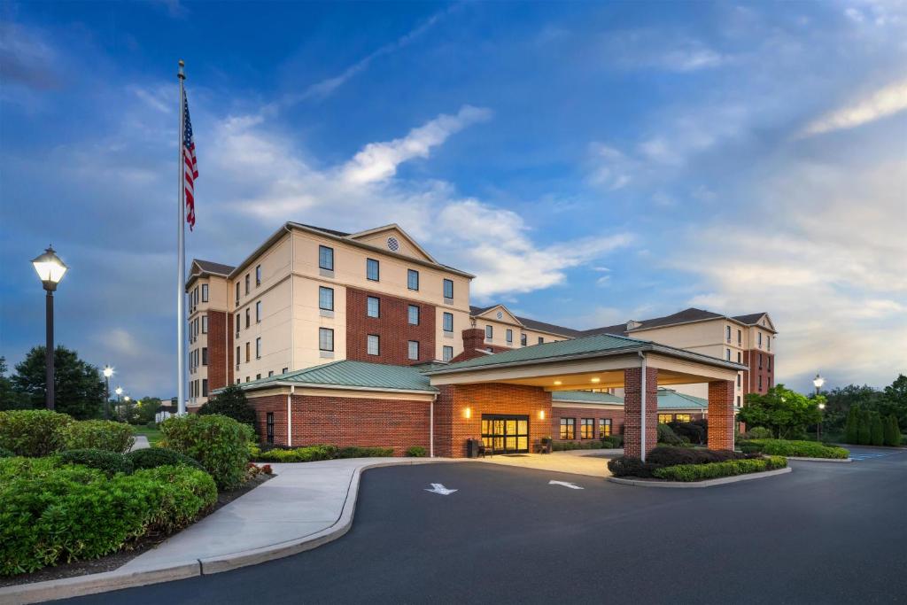 a hotel with a flag in front of a building at Homewood Suites by Hilton Newtown - Langhorne, PA in Newtown