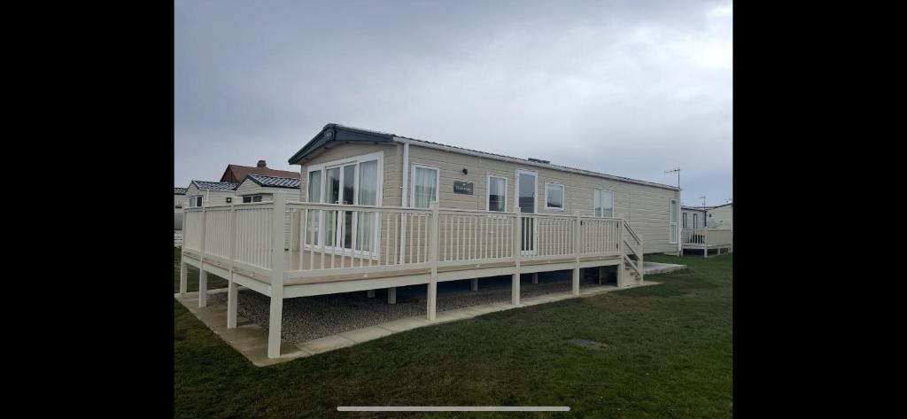 a large house with a large deck in the grass at Fabulous seaside caravan getway at Cayton Bay in Scarborough