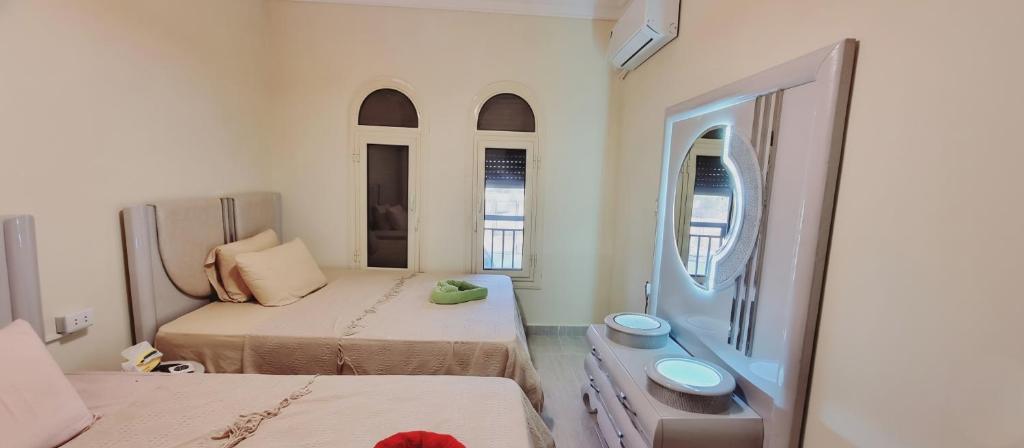 ein kleines Zimmer mit zwei Betten und einem Spiegel in der Unterkunft cozy apartment , La Sirena Palm Beach ,Ain Sokhna in Ain Suchna