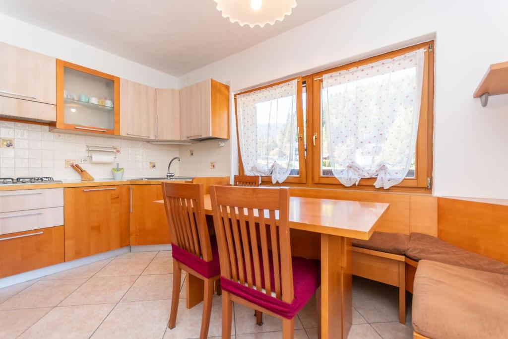 une cuisine avec une table et des chaises de salle à manger en bois dans l'établissement Casa Sangi, à Caviola
