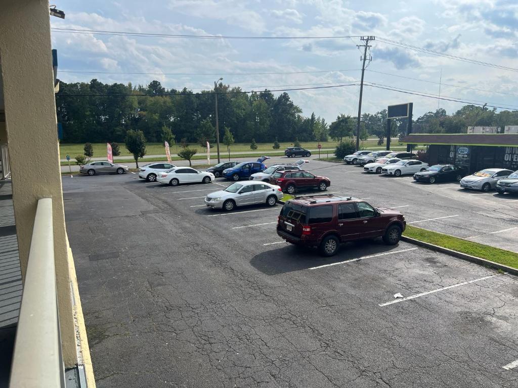 a parking lot with a lot of cars parked at Capitol Inn by Belvilla Richmond Airport VA in Sandston