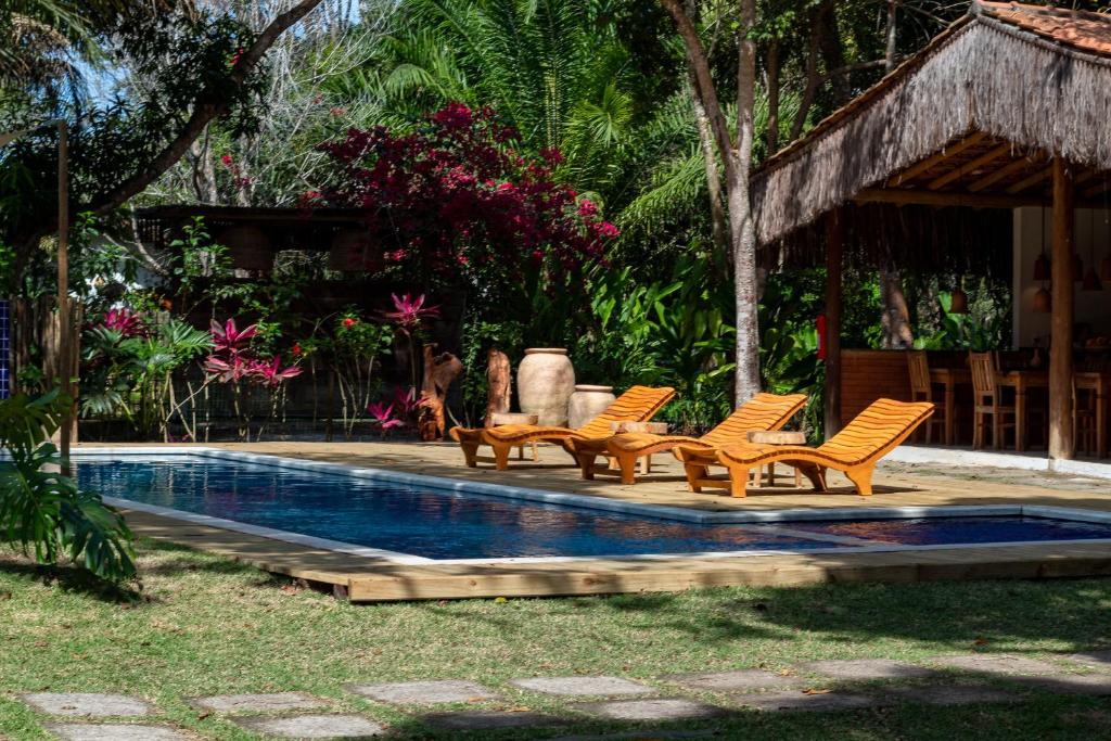 a group of chairs sitting next to a swimming pool at Villa Cacau - Floresta in Trancoso