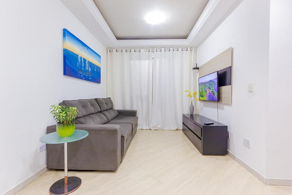 a living room with a couch and a tv at Apartamento de 3 quartos - B31 - Santo André - SP in Santo André