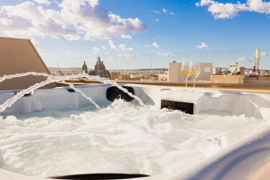 Una bañera llena de nieve con una copa de vino en PH Jacuzzi & Stunning Terrace Near Tarxien Temples, en Tarxien