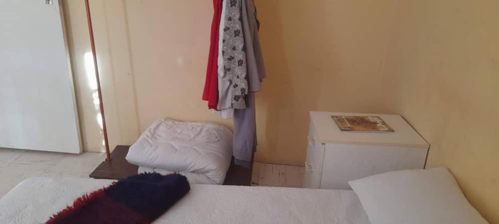 a room with a bed and a table in a room at The Oval House in Otse