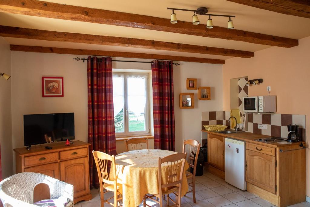 a kitchen and dining room with a table and a tv at La Ferme du Franz in Diefmatten