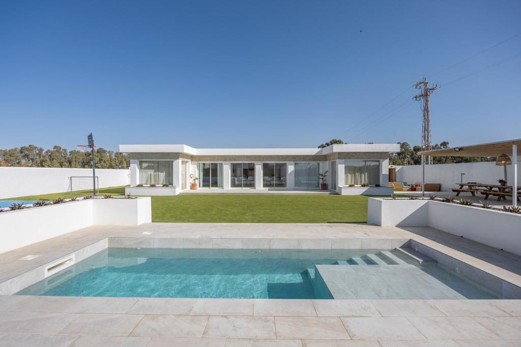 a house with a swimming pool in front of a house at Villa Rocio in Chiclana de la Frontera