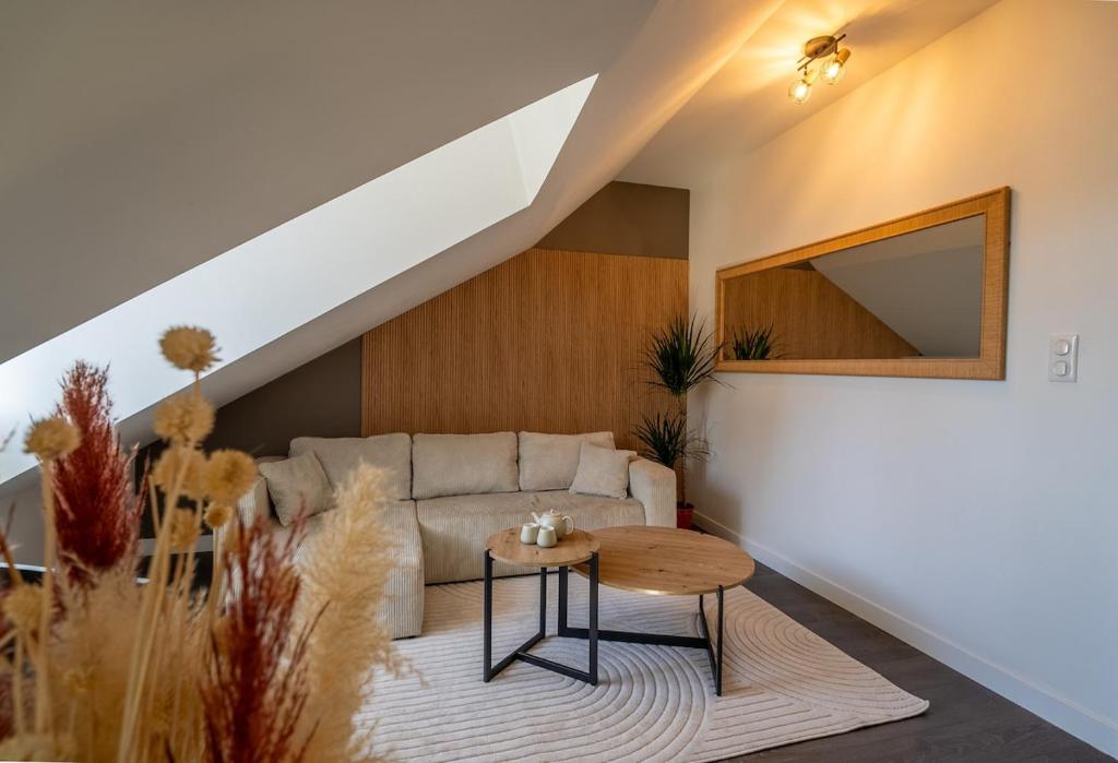 una sala de estar con un sofá y una mesa en Le Loft - Place Flore - Besançon, en Besançon