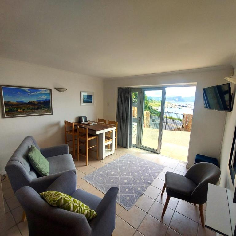 a living room with a couch and chairs and a desk at Seaside haven in Simonʼs Town