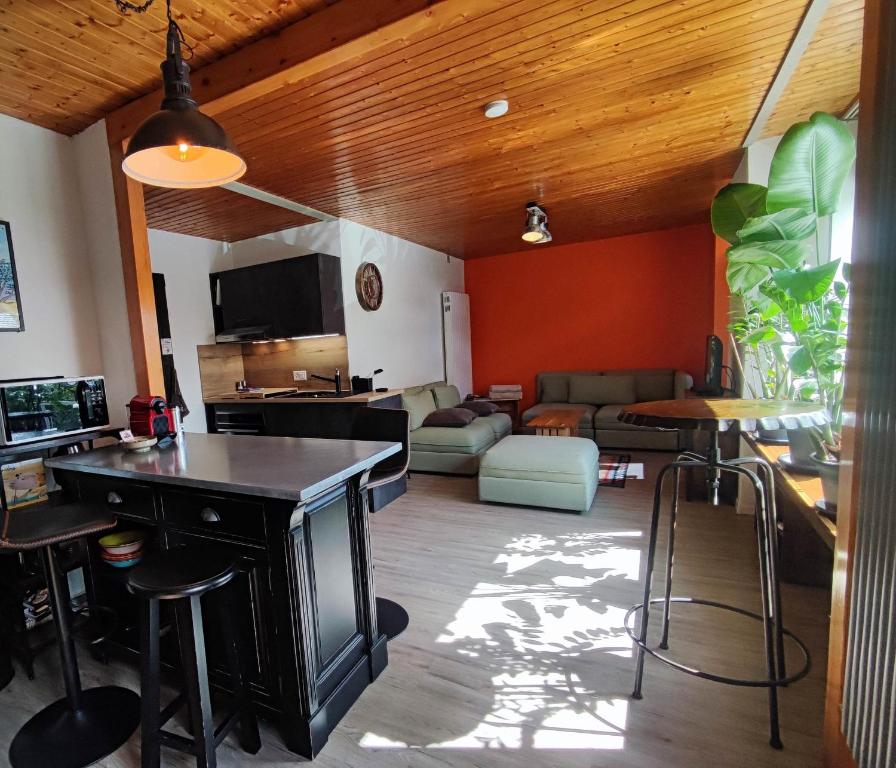 a living room with a table and a couch at Loc Aquatropic appartement de vacances in Bevaix