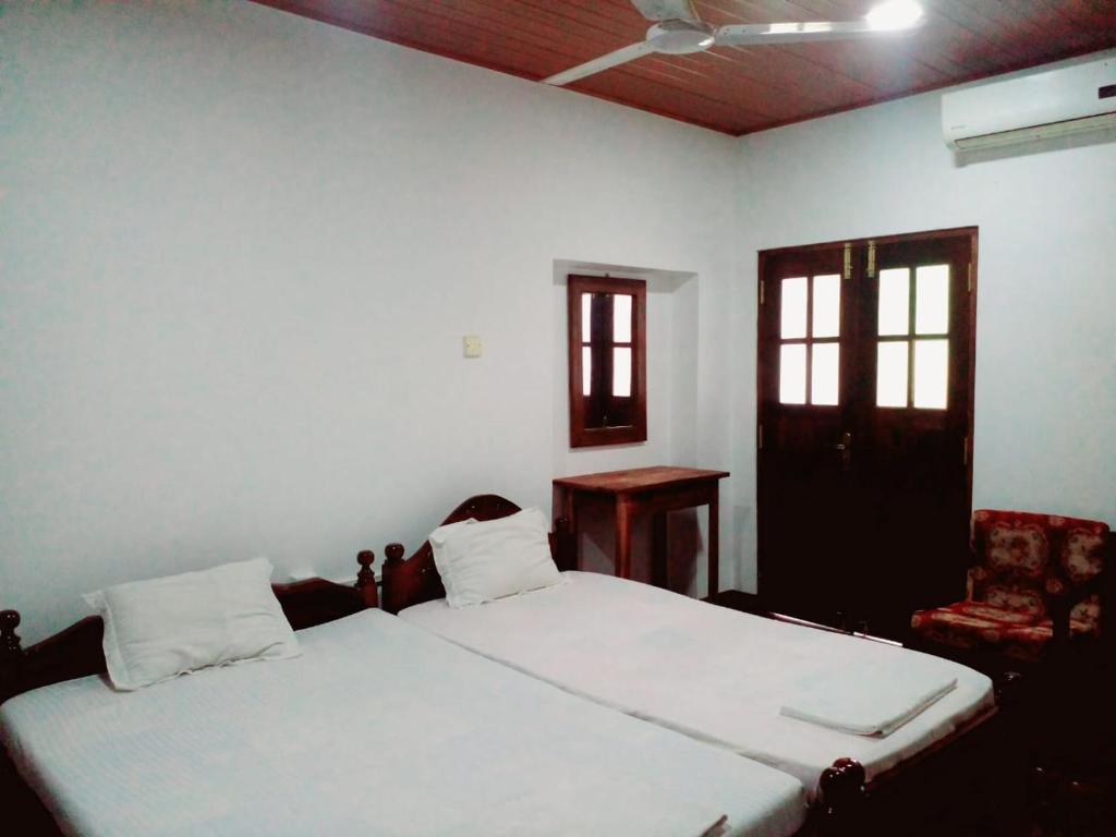 Un dormitorio con una cama blanca y una silla. en The Superson Canel Resort, en Udawalawe