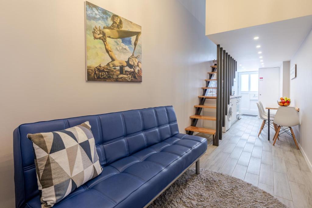 a blue couch in a living room with a staircase at City Views Flats in Historic Porto by HostWise in Porto