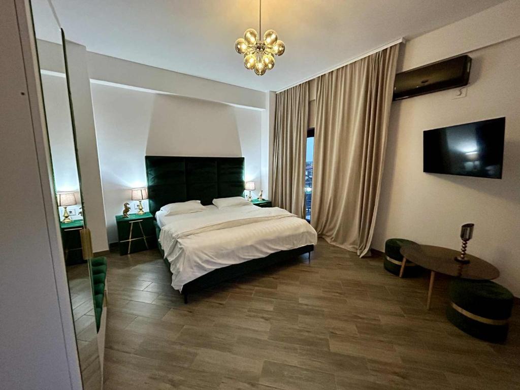 a bedroom with a large bed and a chandelier at Pensiunea Gloria in Afumaţi