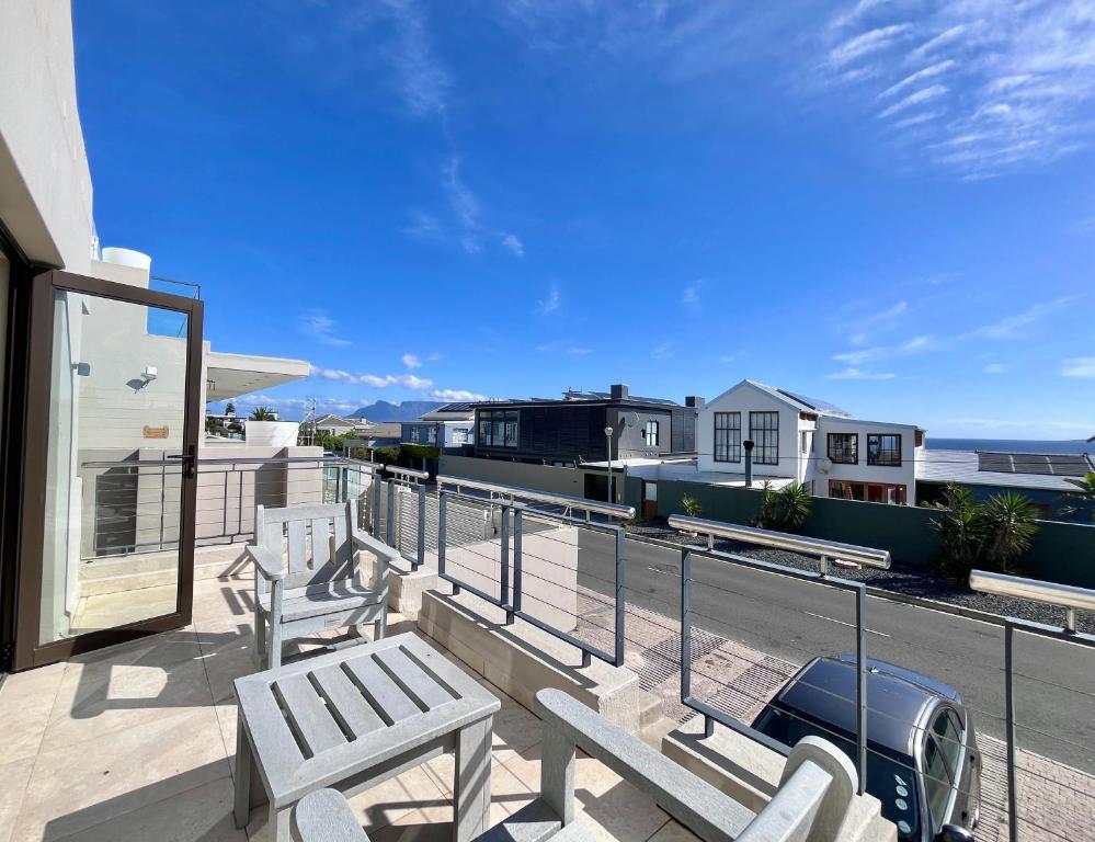 a balcony with benches and a view of the ocean at Blouberg Village Place in Cape Town