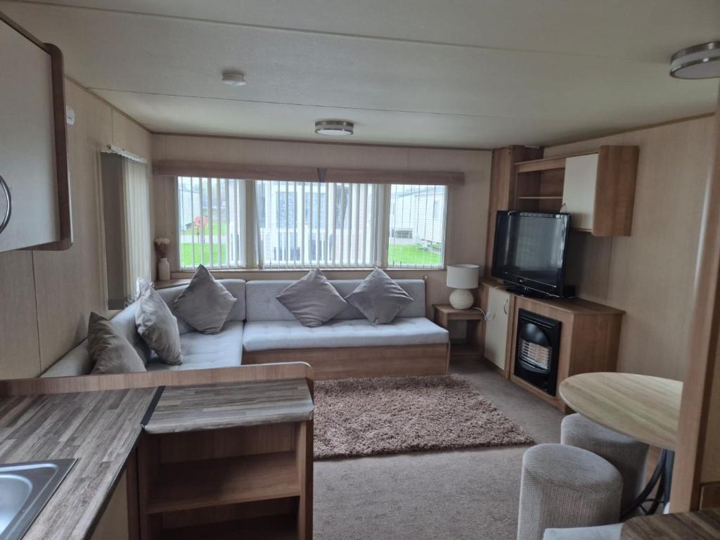 a living room with a couch and a tv at Caravan by the Sea 641 in Kinmel Bay